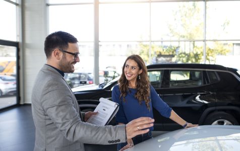 car-dealer-presenting-new-car-customer (1)